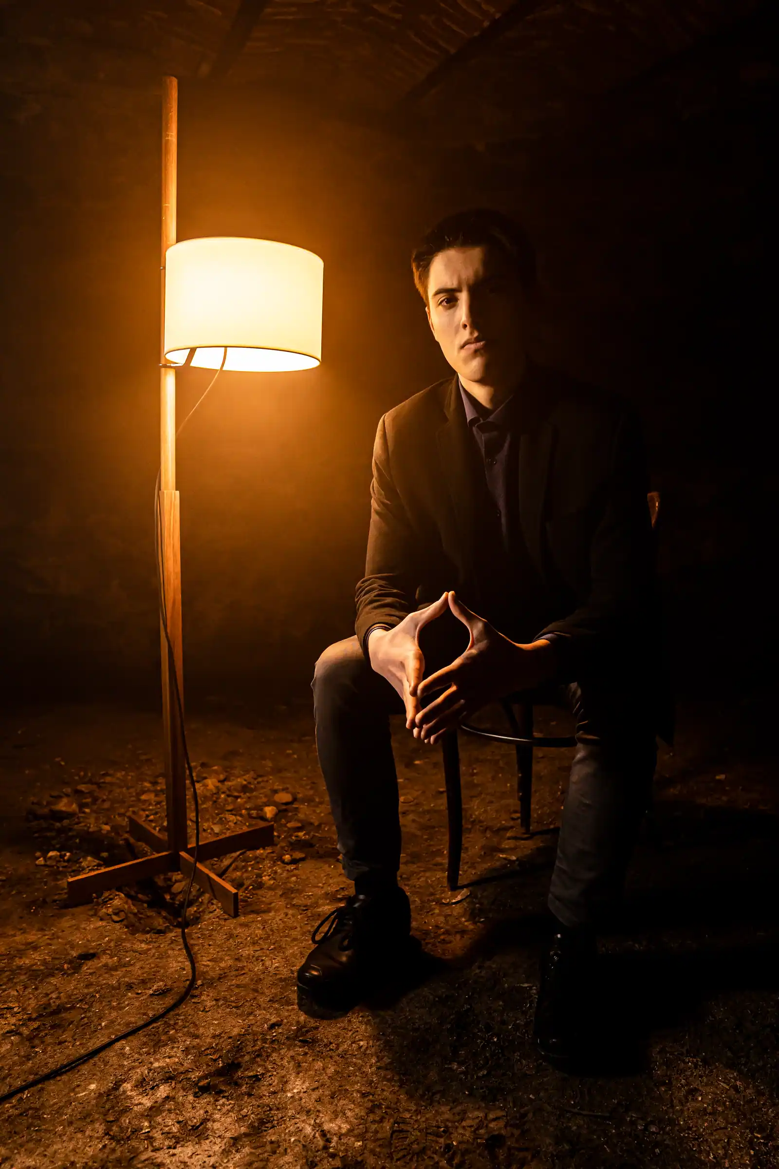 Portrait of Rado Sheytanoff seated beside a warm lamp, direct eye contact